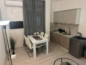 una piccola cucina con un tavolo bianco e un tavolo e sedie di Apt 2- Sokobanjica apartmani a Soko Banja