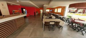 a restaurant with tables and chairs and red walls at Hotel Innove Guaíba in Guaíba