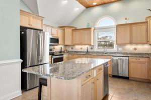 una cucina con mobili in legno e un frigorifero in acciaio inossidabile di Happy Hour a Nags Head