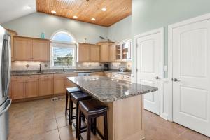 una cucina con una grande isola con sgabelli da bar di Happy Hour a Nags Head