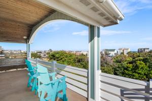 balcone con sedie blu e vista sulla città di Happy Hour a Nags Head Altre 34 foto