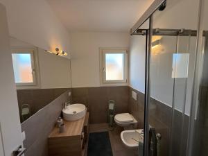 a bathroom with a sink and a toilet and a shower at Residenza Bramante 3 in Olbia +9 photos