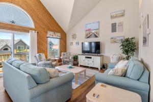 a living room with two couches and a tv at Harrells Retreat in Nags Head