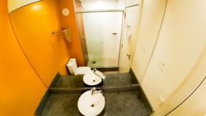 a bathroom with two sinks and a mirror at Hotel Innove Guaíba in Guaíba