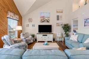 a living room with two blue couches and a tv at Harrells Retreat in Nags Head +48 photos