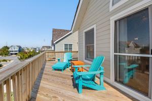 a deck with three chairs and a table on it at Harrells Retreat in Nags Head