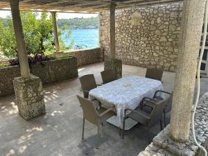 a table and chairs on a patio next to the water at Villa Nada in Banići