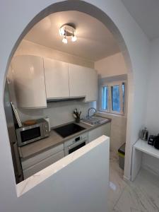 a kitchen with white cabinets and a sink and a microwave at Villa Nada in Banići +29 photos