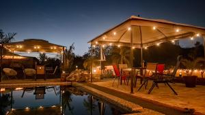 a patio with a table and chairs by a pool at night at Jimmy & Yudy's place in El Triunfo