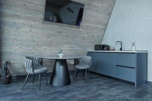 a kitchen with a table and two chairs and a counter at Lago House Bran in Bran