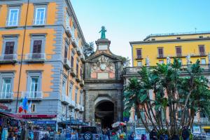 a building with a clock tower in the middle of a street at Dante Luxury Rooms in Naples