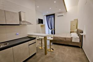 a small kitchen with a bed and a table in a room at Dante Luxury Rooms in Naples +29 photos
