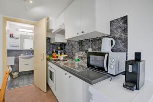 Una cocina con gabinetes blancos y encimera. en Apartment View And Pool - Happy Rentals, en Agno