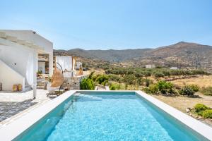 a villa with a swimming pool and mountains in the background at Revery Villa in Ios Chora