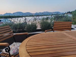 a wooden table with two chairs and a view of the water at Holiday home Ilijaš with home gym in Mihalj