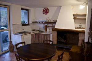 Parte di casa con giardino e piscina في بيتراسانتا: مطبخ مع طاولة خشبية ومدفأة