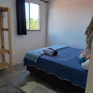 a bedroom with a blue bed with a window at Casa pénareia in Amontada
