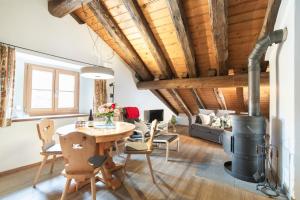 un soggiorno con soffitto in legno, tavolo e sedie. di Chesa Michel a Bever