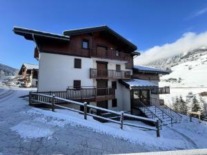 budynek z śniegiem na ziemi przed nim w obiekcie Les Chalets Des Evettes - Agréable appartement au pied des pistes MAE-1724 w mieście Notre-Dame-de-Bellecombe
