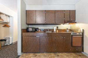 a kitchen with wooden cabinets and a microwave at Beautiful Studio W/Kitchenette #134 at Donner Lake Village in Truckee +11 photos