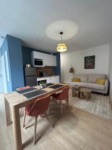 een keuken en woonkamer met een tafel en stoelen bij Côté Pyrénées - Lourdes in Lourdes