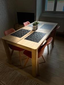 een houten tafel met twee stoelen en een plant erop bij Côté Pyrénées - Lourdes in Lourdes +2 foto's