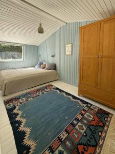 una camera con un letto e un tappeto sul pavimento di Wooden Cottage Near The Beach In Odsherred ad Asnæs