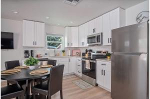 a kitchen with a table and a stainless steel refrigerator at Historic Comfort 2BR1BA Guesthouse Near Riverwalk in San Antonio +27 photos