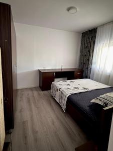 a bedroom with a bed and a wooden floor at Alexander Home in Techirghiol