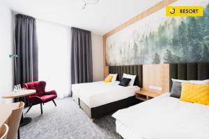 a hotel room with two beds and a chair at DCS Polana Jakuszycka in Szklarska Poręba