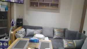 a living room with a gray couch and a table at Studio sympa in Casablanca