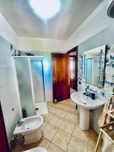 a bathroom with a sink and a toilet and a mirror at Rúnkina in Monte Petrosu