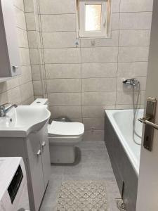 ein Badezimmer mit Toilette, Waschbecken und Badewanne in der Unterkunft Kuzmanovski Apartments in Bitola
