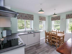 una cucina con un tavolo e una sala da pranzo di 2 Whinstone Cottage a Whitby