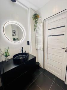 a bathroom with a black sink and a mirror at Apartament Panorama Żory in Żory +4 photos