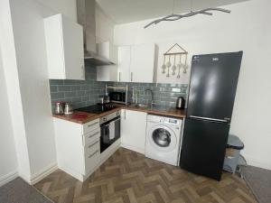 a kitchen with a refrigerator and a washing machine at Abchuch chambers in Bournemouth