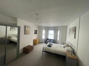a bedroom with a bed and a mirror at Abchuch chambers in Bournemouth
