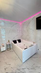 格但斯克Jacuzzi Bliss by the Motława的白色的客房设有电视和大理石墙