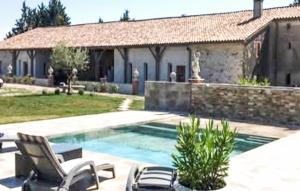a swimming pool with two chairs and a house at Authentique Maison Campagne in Montredon-Labessonnié +19 photos