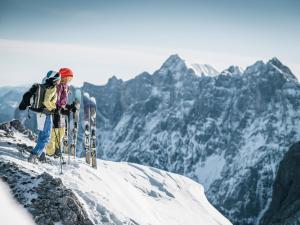 a person standing on top of a mountain with skis at Huberbauer in Johnsbach