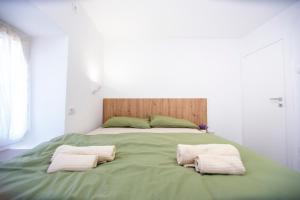 Charming Apartment in The Old Town في بودفا: سرير اخضر كبير عليه منشفتين