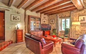 a living room with leather furniture and a television at Authentique Maison Campagne in Montredon-Labessonnié
