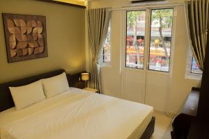 a bedroom with a white bed and a window at Bamboura Home in Hanoi