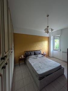 Un dormitorio con una cama y una pared amarilla. en Golden Sea Apartment, en Albisola Superiore