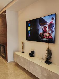 a flat screen tv hanging on a wall at Seaside, Infinity Pools, Gym, Games, Wifi in Tamaris