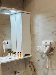 a bathroom with a hair dryer and a mirror at TASY Guest House - Luxury Rooms in the Heart od SHIROK SOKAK in Bitola +26 photos