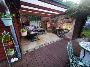 a patio with a table and chairs on a wooden deck at Ferienhaus mit mediterraner Terrasse in Müllrose