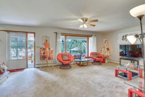 a living room with red chairs and a ceiling fan at Private 5-Acre Lake Pet-Friendly Grove City Home in Grove City