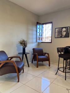 a living room with chairs and a window at Apto Exclusivo a 30m da Praça da Sé - Norões Residence in Crato