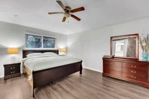 a bedroom with a bed and a ceiling fan at Serene Deck 10 Mins Garland City Square in Garland